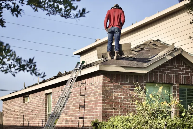 Professional roofer working on a residential roof in Brookfield Center